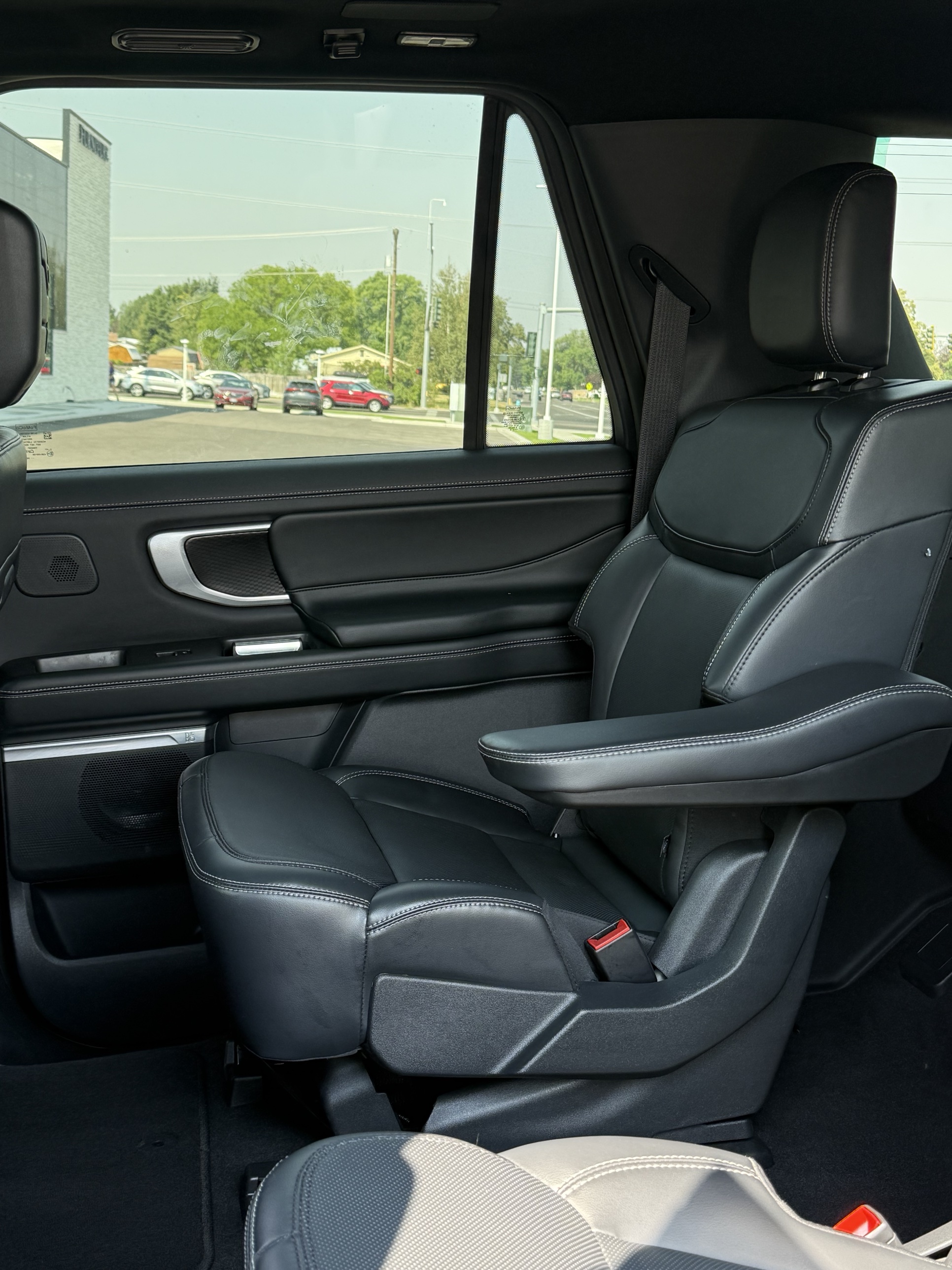 Black SUV rear captain's seat and door panel after an interior detail