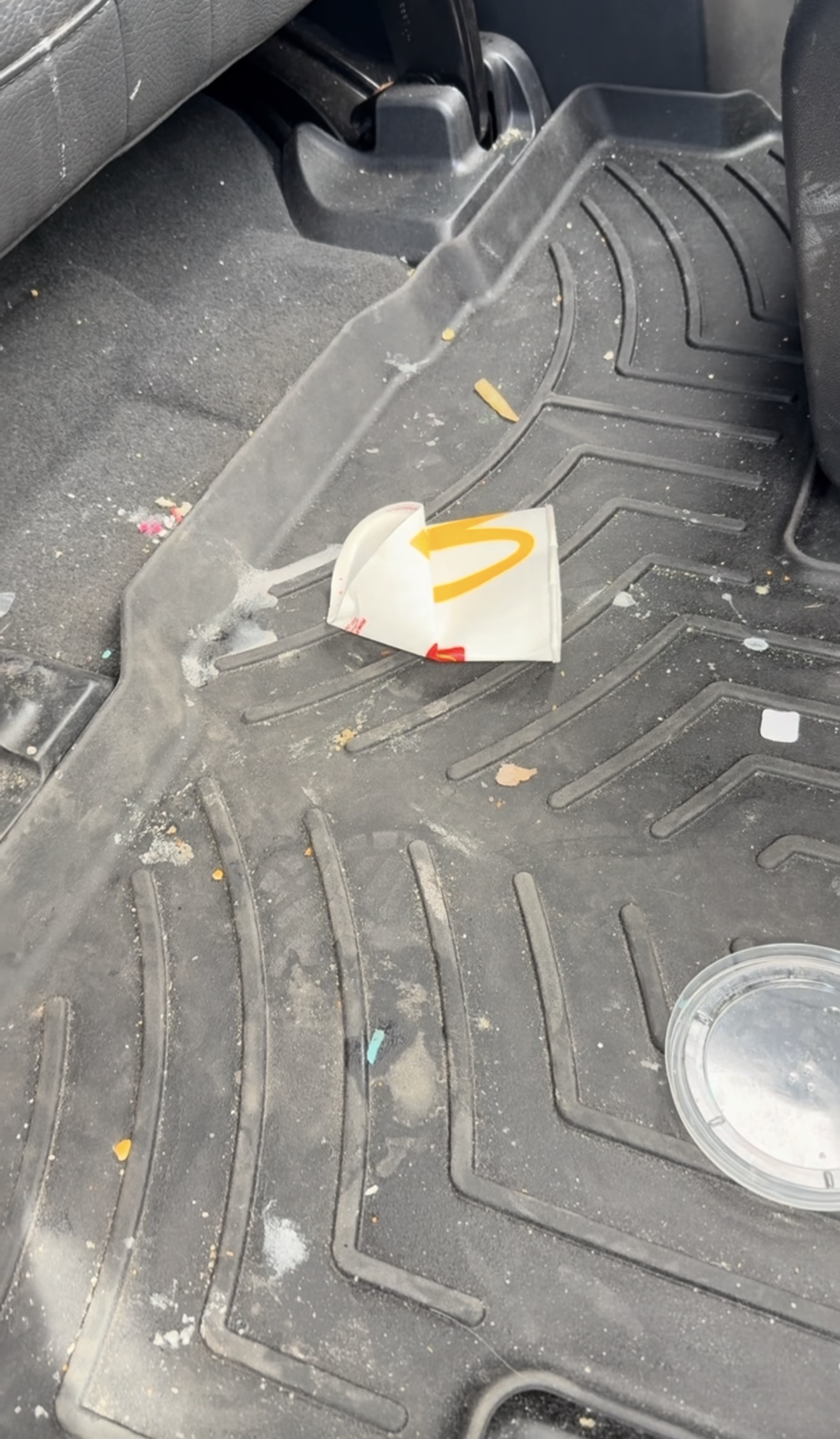 GMC Denali rear floor mat covered in fast food trash and crumbs before a PRO DTLR PRO Reset