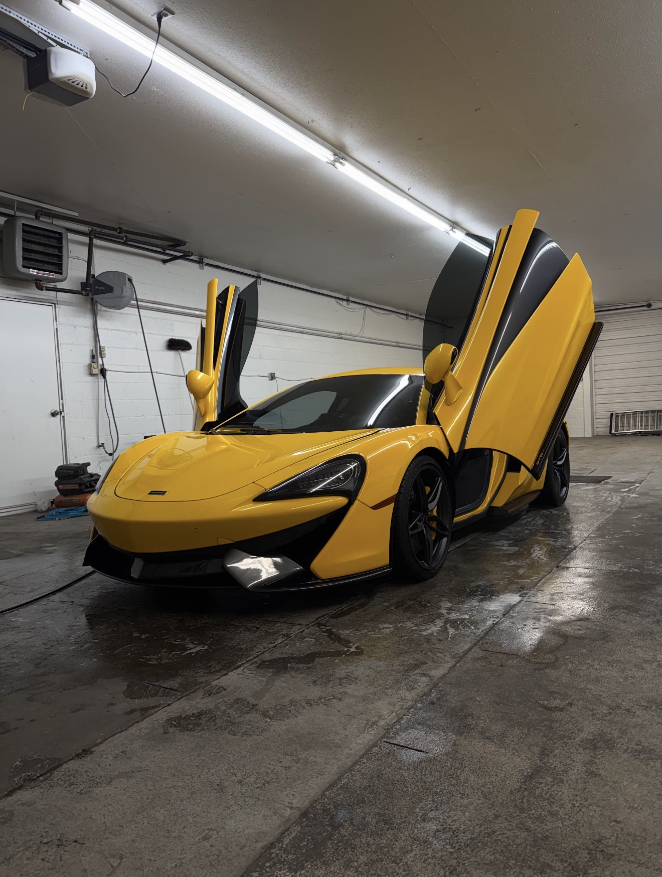 McLaren 570S after a full detail, doors up in a Rexburg garage