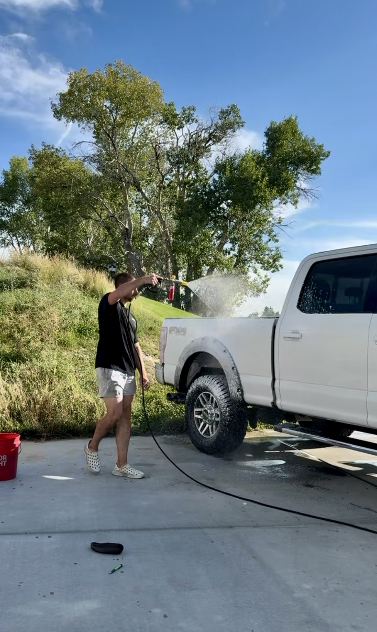 PRO DTLR detailer rinsing a truck during a mobile detailing visit