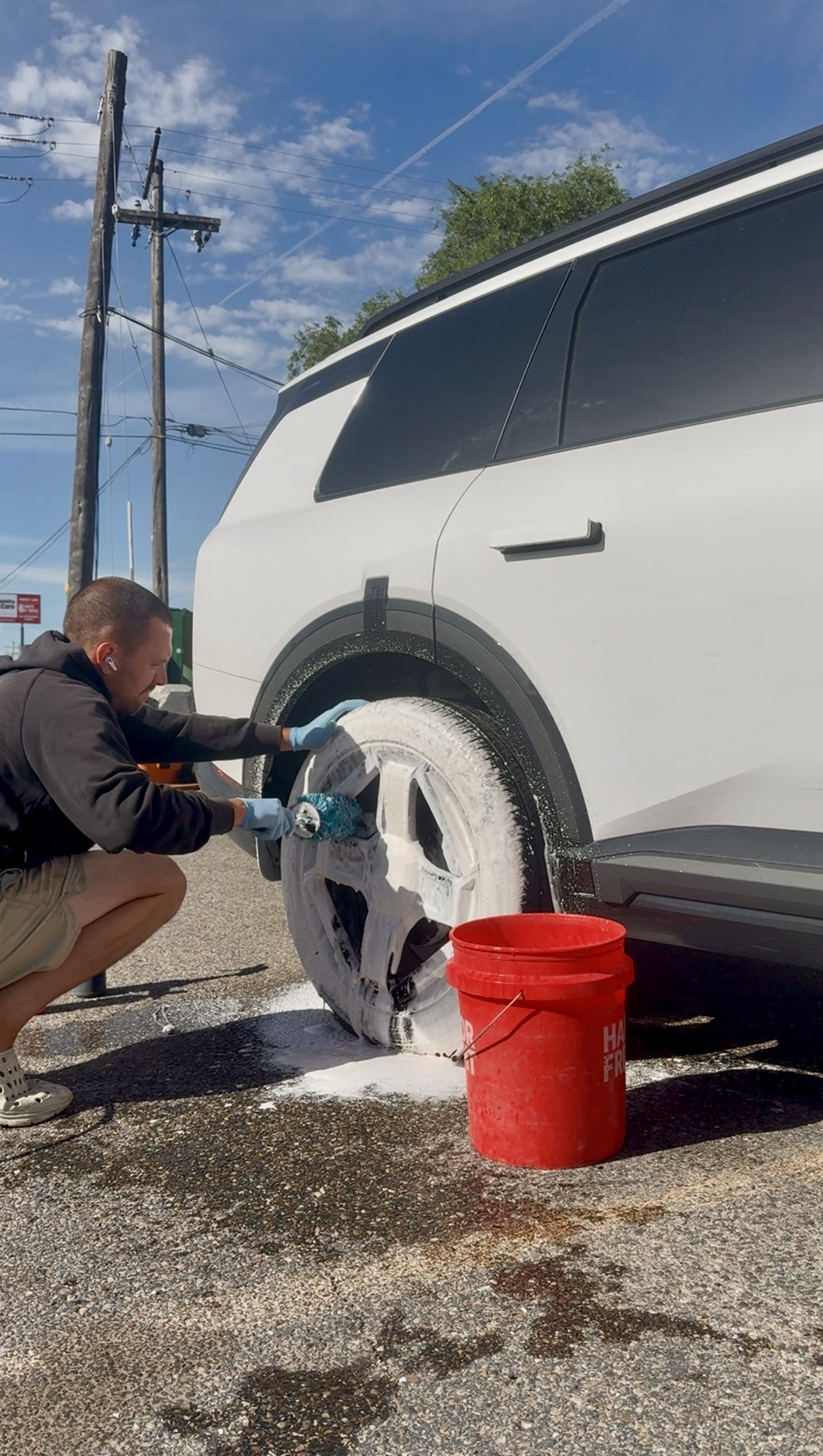 PRO DTLR detailer foam-washing a wheel and fender as part of a full PRO Reset Detail