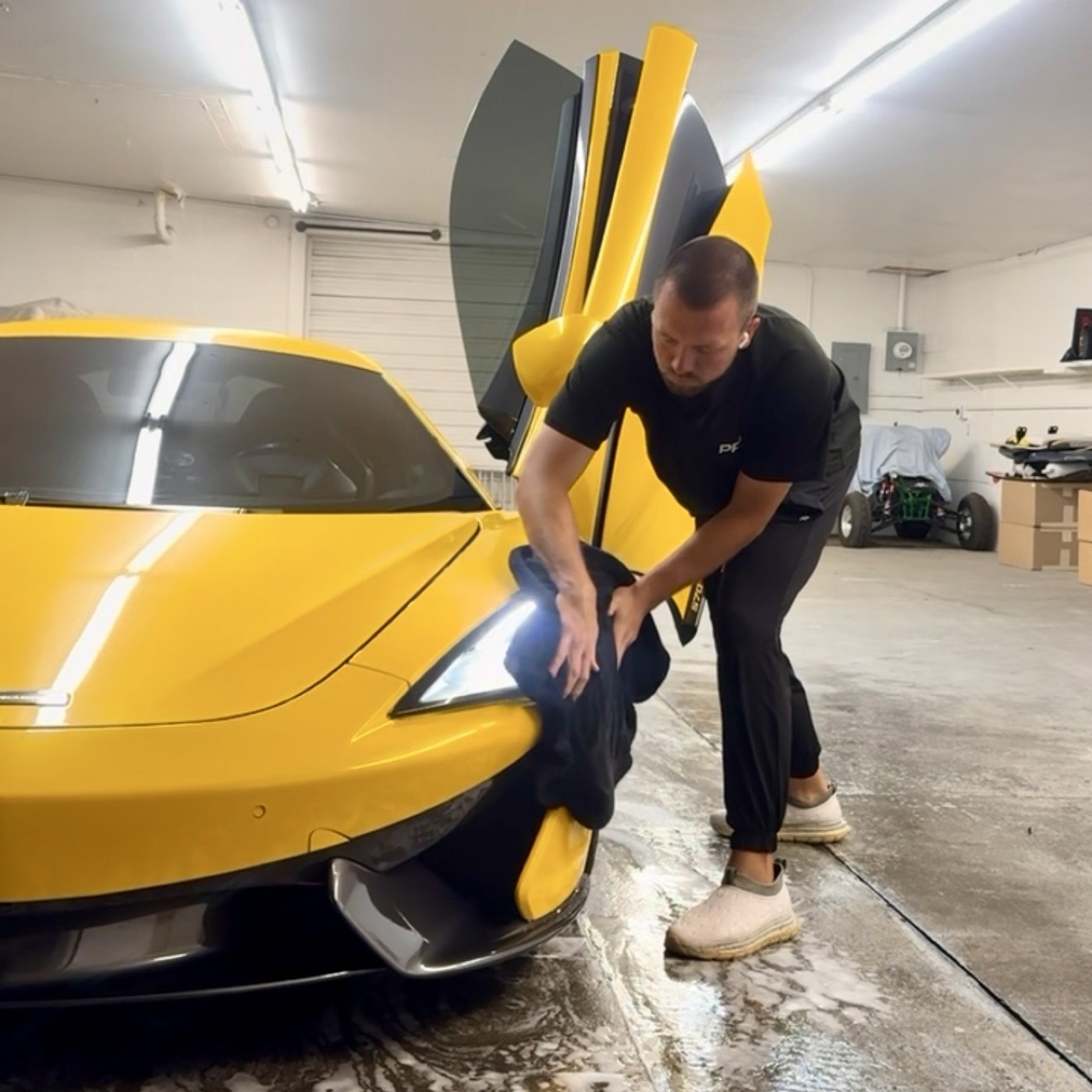 Gage Whatcott, owner of PRO DTLR, hand-drying a car during a mobile detail
